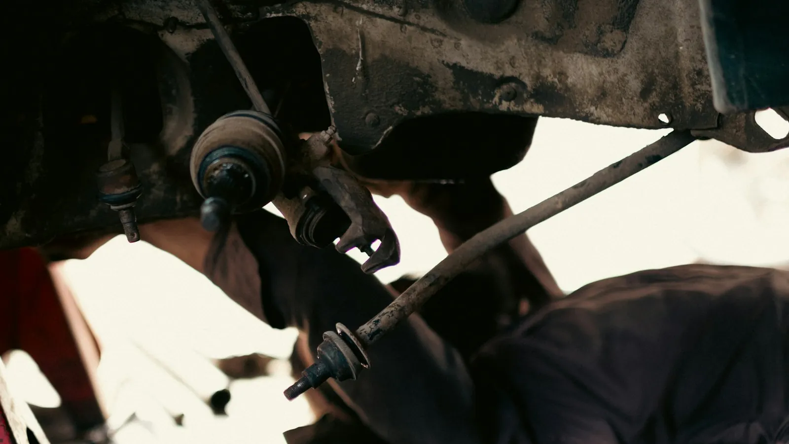 A car raised on a jack stand with its front suspension open