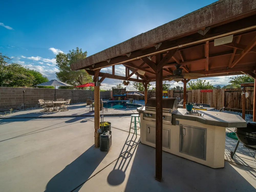A pool deck with a covered patio